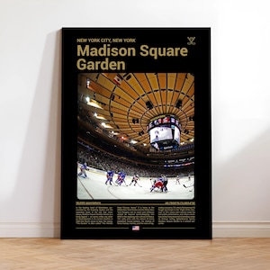 May include: Black poster featuring Madison Square Garden in New York City. The image shows a hockey game in progress, with players in blue and red uniforms. The poster includes the text "Madison Square Garden" in gold lettering.