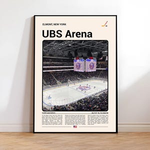 May include: A framed poster featuring the UBS Arena in Elmont, New York. The image shows the ice hockey arena with spectators and a scoreboard. Text at the top reads "Elmont, New York" and "UBS Arena". Additional text and a hockey stick graphic are also present.