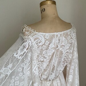 back view of a off-white ivory lace wedding dress on Etsy that features long Bell sleeves in an adjustable waist
