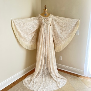 bohemian lace long sleeve wedding dress full length photo with Bell sleeves shown stretched all the way out so that you can see both sleeves with their fringe