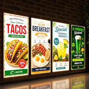 May include: Four vertical illuminated menu boards on a brick wall. The first shows tacos with text Cinco de Mayo Special. The second shows breakfast with text All Day Breakfast. The third shows a pineapple margarita. The fourth shows beer for St. Patrick's Weekend.