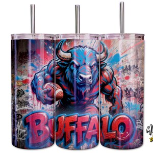 May include: Three stainless steel tumblers with a striking design. A muscular blue buffalo holding a football is set against a graffiti-style background. The word "BUFFALO" is in red. Each tumbler has a silver straw.