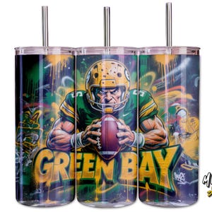 May include: Three stainless steel tumblers with a Green Bay Packers theme. Each tumbler features a football player graphic in a green and gold uniform, holding a football, set against a graffiti-style background. The words "GREEN BAY" are prominently displayed.