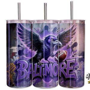 May include: Three stainless steel tumblers with a purple and black design. The design features a raven holding a football, with the word "BALTIMORE" in graffiti style. The tumblers have silver straws.