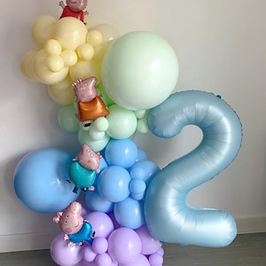May include: A colorful balloon arrangement featuring a large number "2" in light blue, surrounded by various pastel-colored balloons. Several Peppa Pig character balloons are interspersed throughout the display, creating a festive and celebratory atmosphere.
