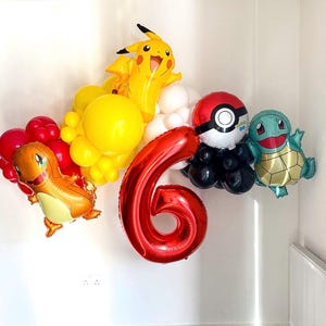 May include: A colorful balloon arrangement featuring a red number 6, a Pikachu balloon, a Charmander balloon, a Squirtle balloon, and a Poké Ball balloon. The balloons are in shades of red, yellow, and blue, perfect for a birthday celebration.