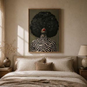 May include: A framed art print featuring a woman with a large, textured black afro and red lipstick. She wears a black and white zebra-striped shirt. The artwork is displayed above a bed with neutral-toned bedding. The text "Art Queen Studio" is visible.