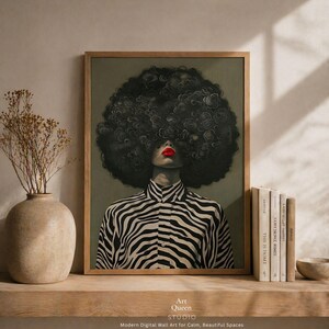 May include: Framed digital wall art featuring a person with a large, dark, curly afro. The person wears a black and white zebra-striped shirt and has bright red lipstick. The art is displayed on a wooden shelf with books and a vase. The text "Art Queen Studio" is visible.