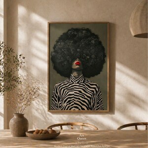 May include: A framed art print featuring a person with a large, dark, curly afro and red lipstick. The person is wearing a black and white zebra-striped shirt. The print is labeled "Art Queen Studio" with text below that reads "Modern Digital Wall Art for Calm, Beautiful Spaces."