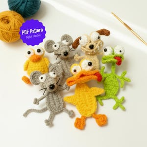 Op de afbeelding: Een verzameling handgemaakte gehaakte dierenfiguren, waaronder een eend, een kikker, een hond en muizen. De figuren zijn in verschillende kleuren, zoals geel, groen, grijs en beige. De afbeelding bevat ook bollen wol en een haaknaald. De tekst "PDF Pattern Digital Crochet" is zichtbaar.