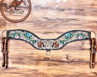 Puede incluir: Pecho de caballo de cuero Aussie Craft. El collar de cuero negro presenta diseños florales y de cabeza de caballo en tonos verdes, rosas y azules. El collar tiene correas de cuero marrón y anillos de metal plateado.