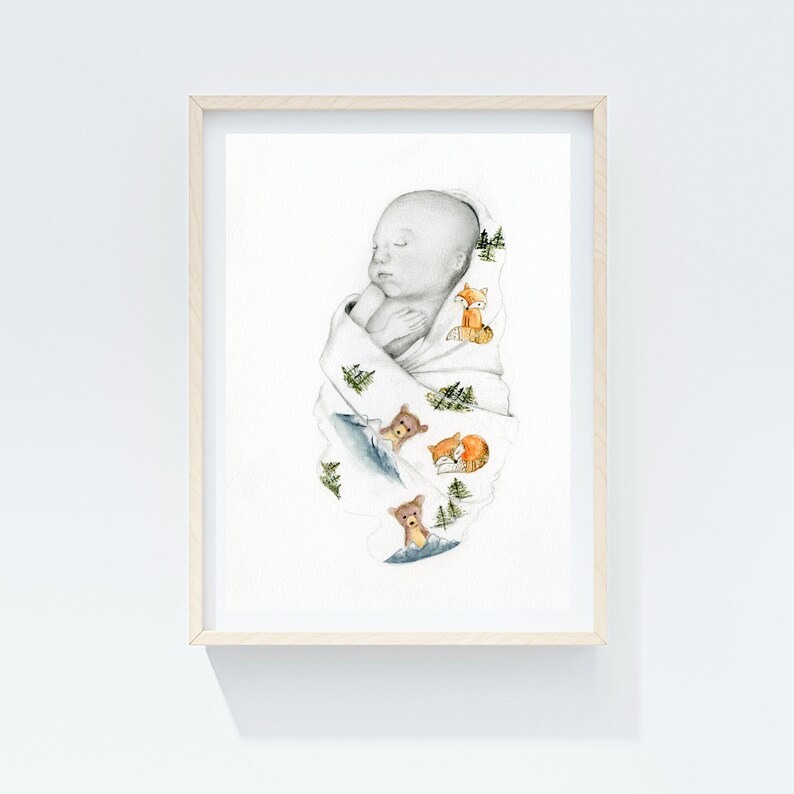 May include: A framed watercolor print of a sleeping baby wrapped in a white blanket. The blanket is decorated with illustrations of foxes, bears, and evergreen trees. The artwork is set against a white background.
