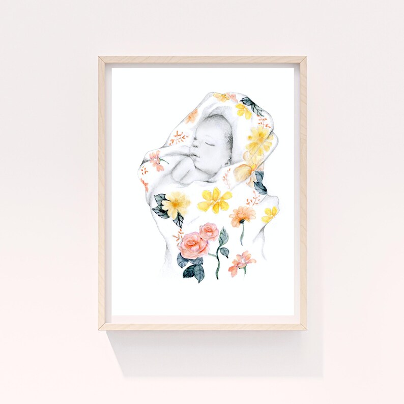 May include: Watercolor art print of a sleeping baby wrapped in a floral blanket. The blanket features yellow, orange, and pink flowers with green leaves. The artwork is framed in a light wood frame.