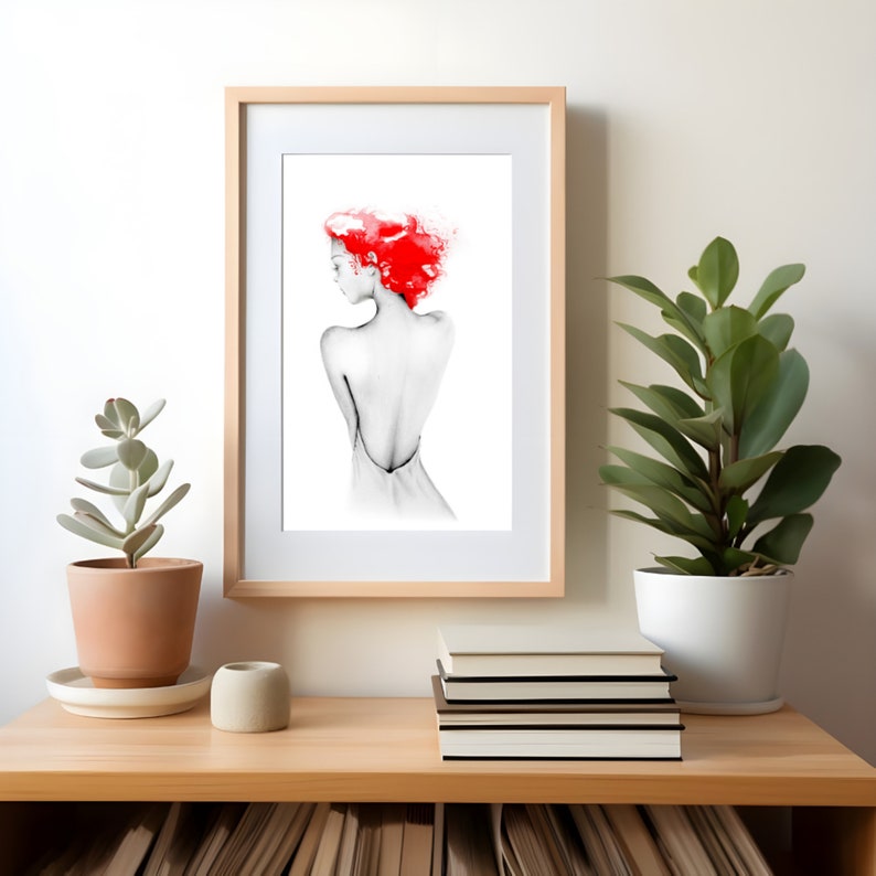 May include: A framed black and white illustration of a person with red hair, standing with their back to the viewer. The person is wearing a white dress.