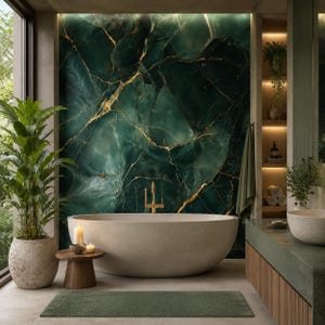 May include: A luxurious bathroom featuring a large, oval-shaped bathtub. The focal point is a dark green marble wall with gold veining. A small wooden side table holds candles. The room includes a green rug, plants, and a stone sink.