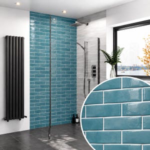 Peut inclure: Un intérieur de salle de bain avec des carreaux de métro bleu sarcelle brillants disposés en briques sur le mur. L'espace comprend un grand radiateur vertical noir, une cabine de douche en verre avec pommeau argenté et une fenêtre.