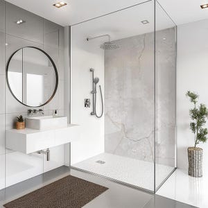 May include: Contemporary bathroom with a glass shower enclosure, a rainfall showerhead, and a handheld shower. The room features a white floating vanity with a rectangular sink, a round mirror, and a brown woven rug.