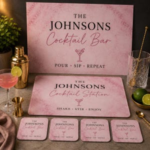 Puede incluir: Un conjunto de accesorios de bar personalizados con patrón de mármol rosa que incluye un letrero rectangular grande, una alfombrilla rectangular más pequeña y cuatro posavasos cuadrados. Cada pieza presenta el texto negro THE JOHNSONS Cocktail Bar o Station.