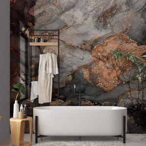 May include: A modern bathroom with a white oval bathtub and a black metal stand. The wall features a large, abstract mural with gray, brown, and gold tones. A wooden side table holds toiletries, and a black metal rack displays towels.
