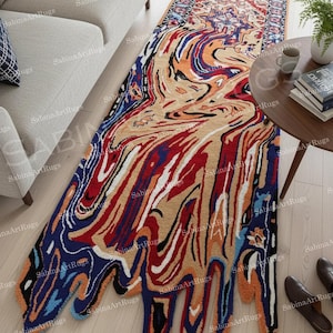 Puede incluir: Una colorida alfombra abstracta con un diseño único y fluido. La alfombra presenta una mezcla de tonos rojos, azules, naranjas y beige, creando un efecto marmolado. La alfombra mide aproximadamente 90 x 180 cm, ideal para añadir un toque audaz a cualquier habitación.