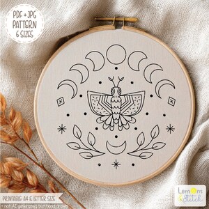 May include: An embroidery hoop with a cream-colored fabric featuring a black line art design. The design includes a central moth, crescent moons, stars, and leaves. Text on the image reads "PDF + JPG PATTERN 6 SIZES" and "PRINTABLE A4 & LETTER SIZE".