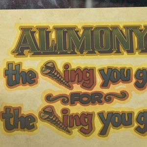 May include: A vintage-style print with the word "ALIMONY" in large, green and brown letters. Below, the text reads "the thing you get for the thing you got!" with screw illustrations. The background is a light yellow.