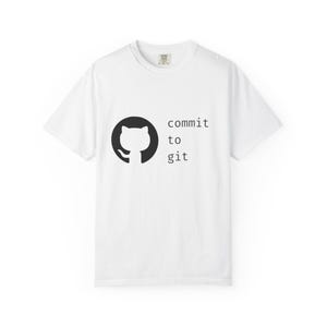 May include: White t-shirt featuring a black graphic of a cat-like figure inside a circle, with the words "commit to git" printed in black. The shirt has a crew neck and short sleeves.