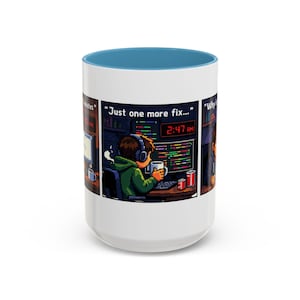 May include: White ceramic coffee mug with a blue interior rim. The mug features a pixelated cartoon design of a person coding late at night, with the text "Just one more fix..." and the time 2:47 AM.