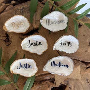 May include: A set of three ceramic mugs with a speckled, matte finish. The mugs are in shades of cream, light gray, and dark gray. Each mug has a simple, minimalist design, perfect for coffee or tea.