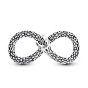 May include: A silver-coloured infinity symbol ring with a snake design. The ring features a detailed snake head at the centre, with the snake's body forming the infinity shape. The ring is made of a shiny, metallic material.
