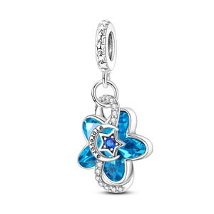 May include: A silver charm featuring a blue flower-shaped crystal with a central star and crescent moon motif. The crescent moon is engraved with the word forever. The charm includes a bail decorated with small stars and clear crystals.
