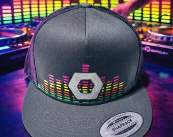 Gorra de camionero gris con diseño de pirámide y mosaico geométrico