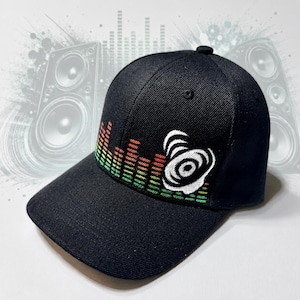 May include: A black baseball cap featuring an embroidered graphic of a colorful sound equalizer bar in red, yellow, and green, alongside a white circular speaker icon. The cap has a structured crown, a flat brim, and a button on the top center.