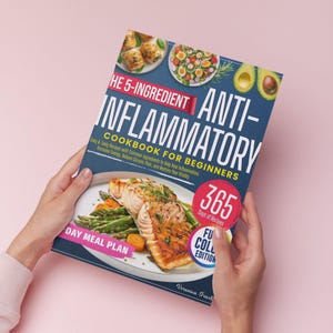 Puede incluir: Una persona sostiene un libro de cocina titulado "The 5-Ingredient Anti-Inflammatory Cookbook for Beginners". La portada muestra im&aacute;genes de platos y el texto "365 d&iacute;as de recetas" y "Full Color Edition". El libro trata sobre recetas antiinflamatorias.