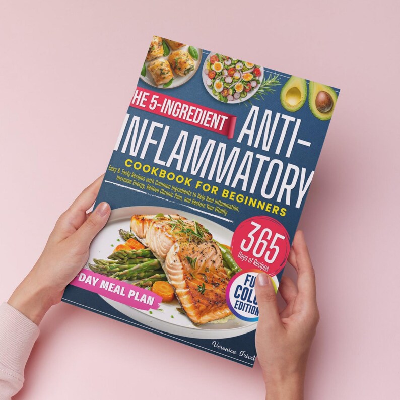 Puede incluir: Una persona sostiene un libro de cocina titulado "The 5-Ingredient Anti-Inflammatory Cookbook for Beginners". La portada muestra im&aacute;genes de platos y el texto "365 d&iacute;as de recetas" y "Full Color Edition". El libro trata sobre recetas antiinflamatorias.