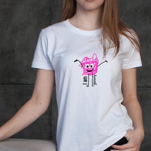 Könnte beinhalten: Weißes T-Shirt mit einer rosa Cartoon-Grafik mit der Aufschrift „Ich bin ehrlich“. Die Grafik zeigt ein lächelndes Gesicht mit Armen und Beinen. Das Shirt ist ein klassischer Rundhalsausschnitt.