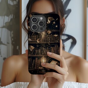 May include: Black phone case featuring a detailed illustration of a library bookshelf with floating books and a glowing light. The design includes stacks of books in various sizes and colors, creating a vintage aesthetic.