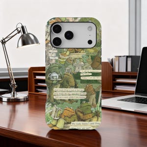 May include: A phone case featuring a whimsical illustration of frogs in a storybook setting. The design includes text excerpts and a charming, vintage aesthetic. The case is designed to fit a smartphone.