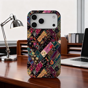 May include: A patterned phone case with a patchwork design. The case features floral and geometric patterns in red, purple, green, and black. The case is made of a hard, protective material.