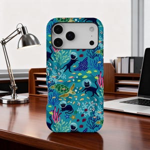 Peut inclure: Coque de téléphone turquoise avec un motif sous-marin. Elle présente des chats noirs avec des casques spatiaux, des tortues de mer, des raies et des poissons. Le motif comprend des coraux et des algues, créant un thème aquatique fantaisiste.