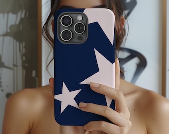 May include: A navy blue and light pink phone case featuring a star pattern. The case has a dark navy blue background with two large white stars and a light pink section. The phone case is held in front of a person.