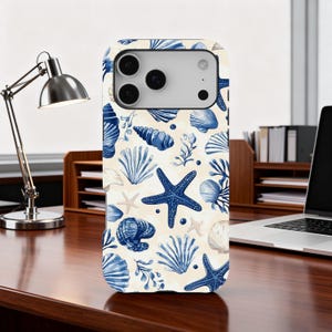 May include: A smartphone case with a repeating pattern of blue seashells, starfish, and aquatic plants on a cream background. The case has a glossy finish. The design includes various shell types and starfish. The case is designed for a smartphone.