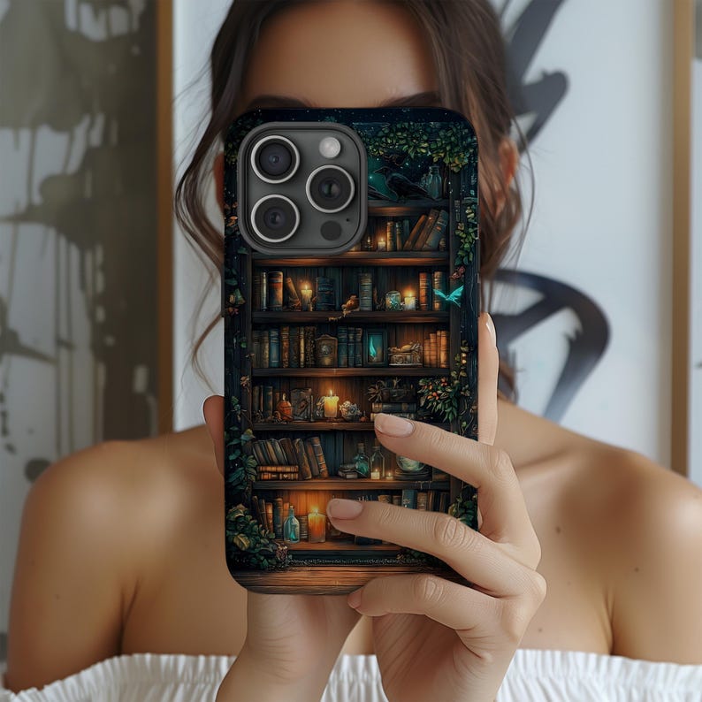 May include: A phone case featuring a detailed illustration of a bookshelf filled with books, candles, and decorative items. The design includes a dark, moody color palette with hints of green and blue, creating a cozy, fantasy aesthetic.