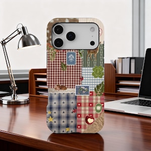 Puede incluir: Funda de teléfono decorativa con diseño de patchwork. La funda presenta una mezcla de patrones, incluyendo cuadros vichy, estrellas y estampados florales, con un ciervo y una pequeña ilustración de gato. La funda tiene un borde marrón claro.