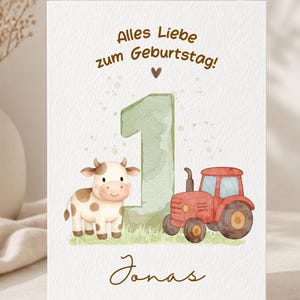 Könnte beinhalten: Eine weiße Grußkarte mit einer großen, aquarellierten Zahl Eins in Salbeigrün, einer braun-weiß gefleckten Kuh und einem roten Traktor auf einer grünen Wiese. Der Text lautet Alles Liebe zum Geburtstag und der Name Jonas in brauner Schreibschrift.