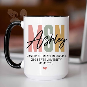 May include: White ceramic mug with a black handle and rim. The mug features the text "MSN Ashley" in a mix of colors, along with "MASTER OF SCIENCE IN NURSING OHIO STATE UNIVERSITY 05.04.2026" and a small heart.