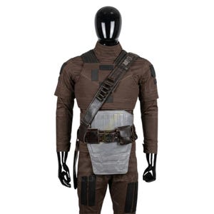May include: A brown tactical costume set featuring a high-neck long-sleeve top and matching trousers with black rectangular patches. It includes a grey chest and abdominal armor plate, a dark brown utility belt with a pouch, and a shoulder strap.