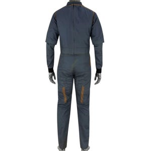 May include: A gray jumpsuit with brown accents. The jumpsuit has long sleeves with black cuffs, a collar, and a zipper down the front. Brown stitching and patches are visible on the garment. The jumpsuit is displayed on a mannequin.