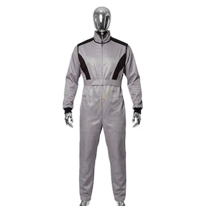 May include: A gray racing suit with black accents on the shoulders and chest. The suit has a zip-up front, a belt, and black cuffs at the wrists. The mannequin is wearing the one-piece garment.