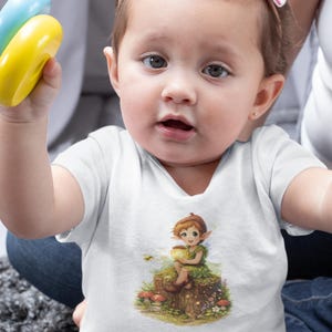May include: A white baby bodysuit featuring a colorful illustration of a fairy sitting on a tree stump. The fairy is holding a glowing orb. The baby is also holding a blue and yellow toy.